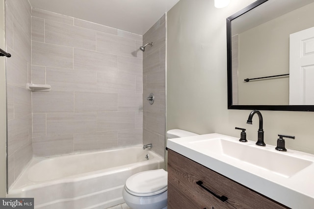 full bathroom featuring tiled shower / bath, vanity, and toilet