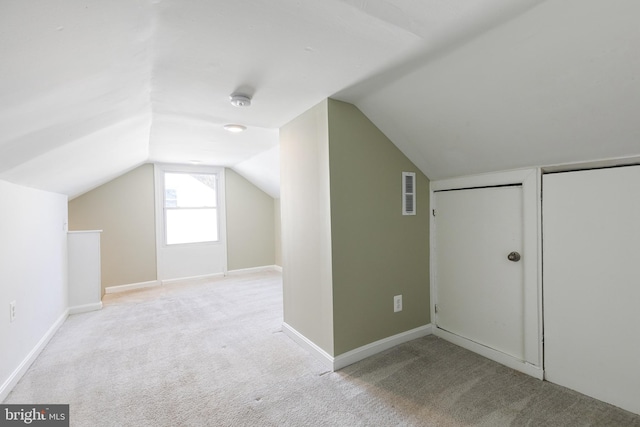 bonus room with light colored carpet and lofted ceiling