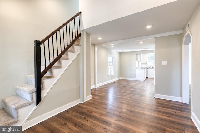 staircase with hardwood / wood-style floors and sink