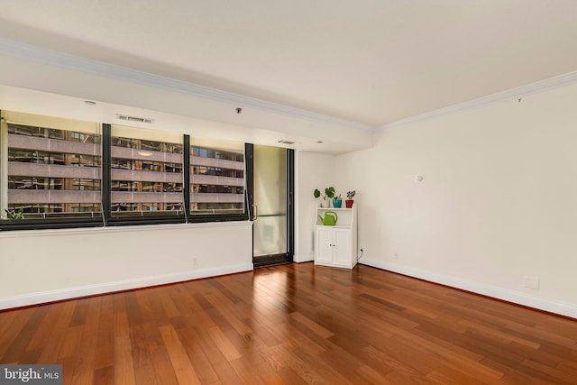 spare room featuring hardwood / wood-style flooring and ornamental molding