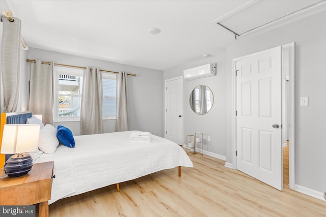 bedroom with a wall unit AC and hardwood / wood-style floors