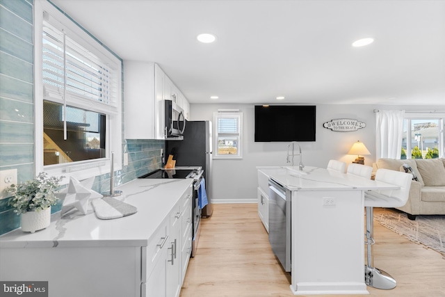 kitchen featuring white cabinetry, a wealth of natural light, and stainless steel appliances