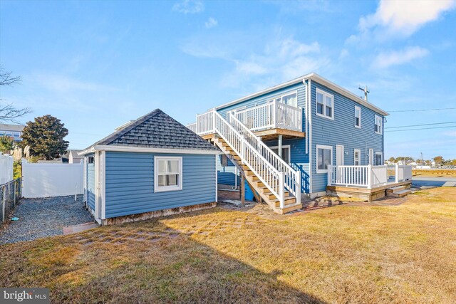 rear view of property with a yard and a deck