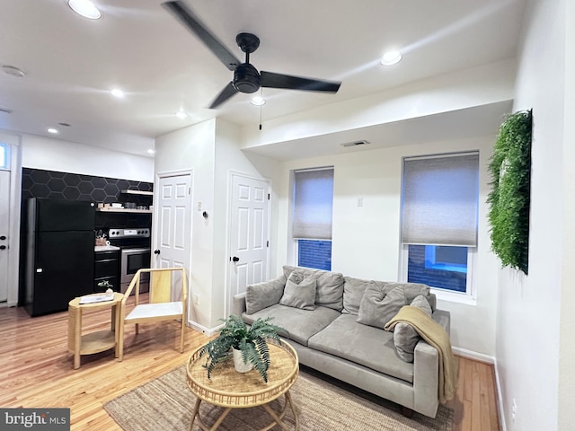 living room featuring ceiling fan and wood-type flooring