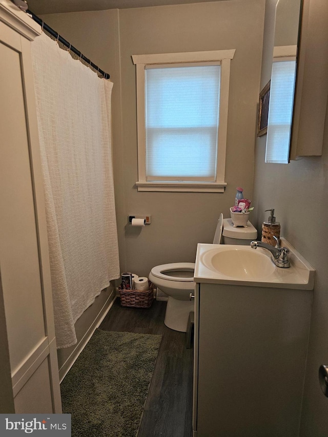 bathroom with hardwood / wood-style floors, vanity, and toilet