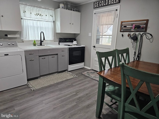 kitchen with white cabinetry, sink, white electric range oven, washer / clothes dryer, and light wood-type flooring