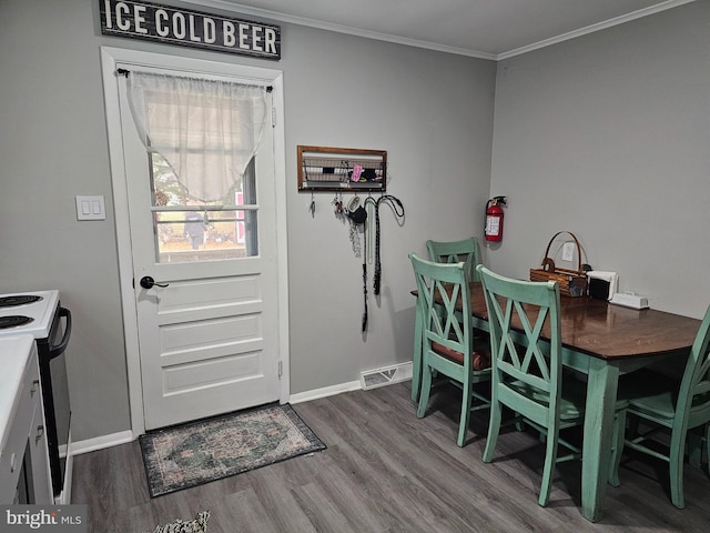 dining room with hardwood / wood-style floors and crown molding