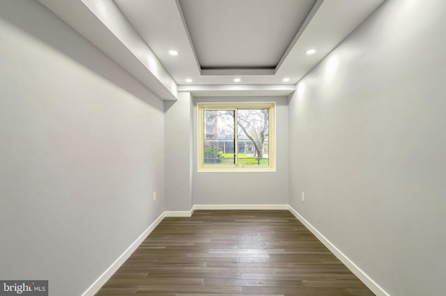 interior space with dark hardwood / wood-style floors and a raised ceiling