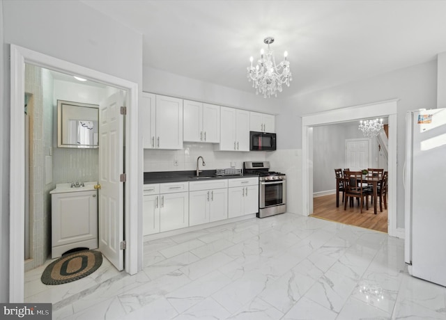 kitchen with a chandelier, stainless steel gas stove, white refrigerator, and sink