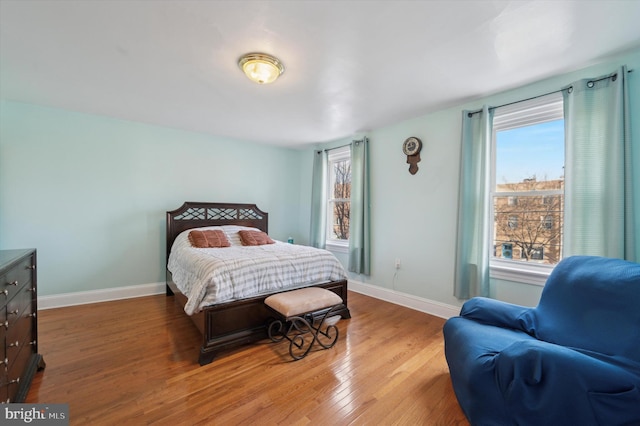 bedroom with multiple windows and light hardwood / wood-style flooring