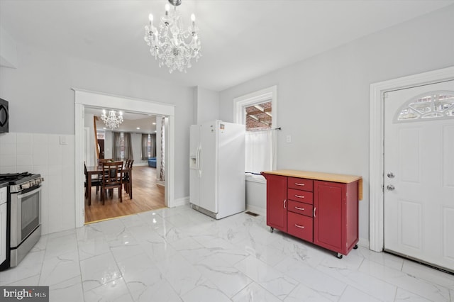 foyer featuring tile walls and a notable chandelier