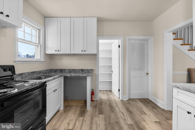 kitchen with stone counters, electric range, light hardwood / wood-style flooring, and white cabinetry