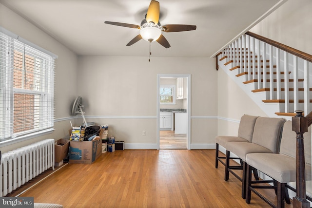 sitting room with a healthy amount of sunlight, light wood-type flooring, and radiator