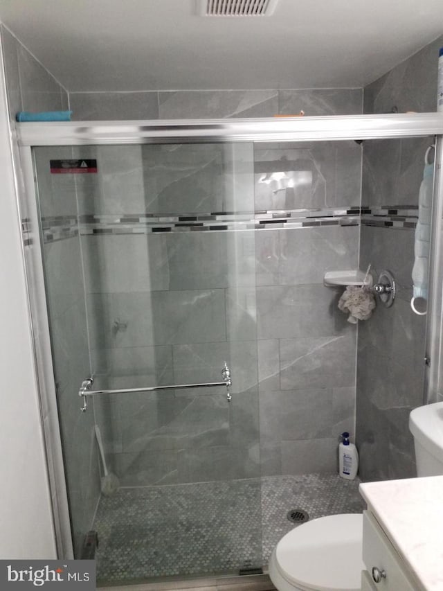 bathroom with vanity, toilet, and walk in shower