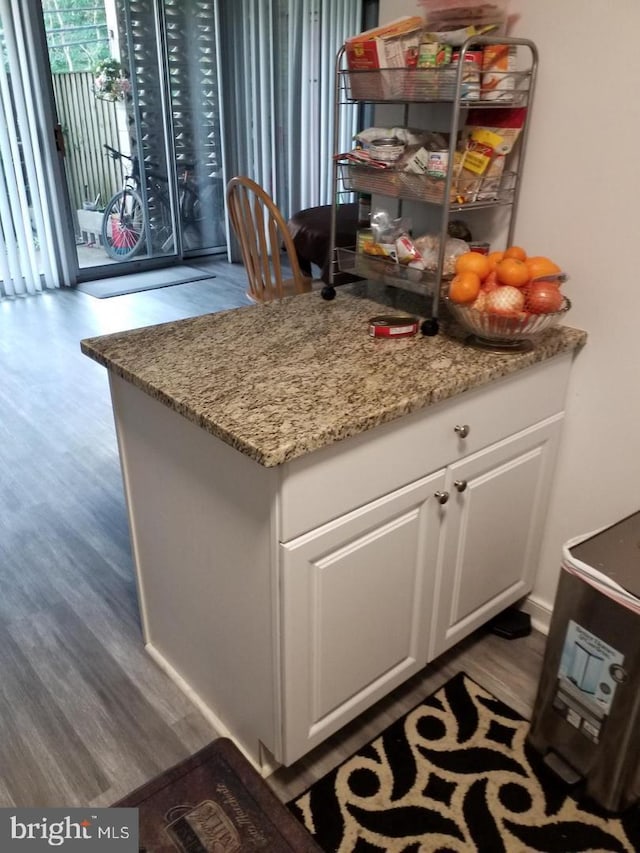 kitchen with white cabinetry, dark hardwood / wood-style flooring, and light stone counters