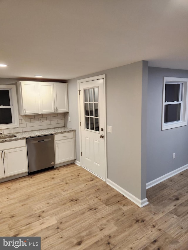 kitchen with white cabinets, dishwasher, light hardwood / wood-style flooring, and tasteful backsplash