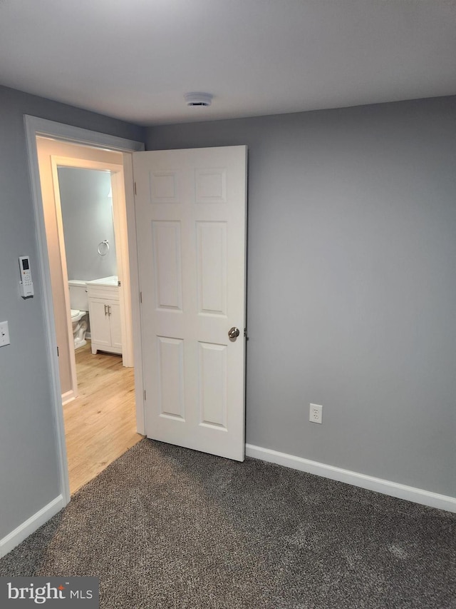 unfurnished bedroom with carpet and ensuite bath