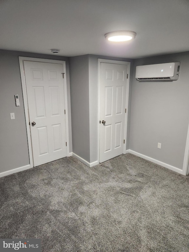 basement with a wall mounted air conditioner and carpet floors