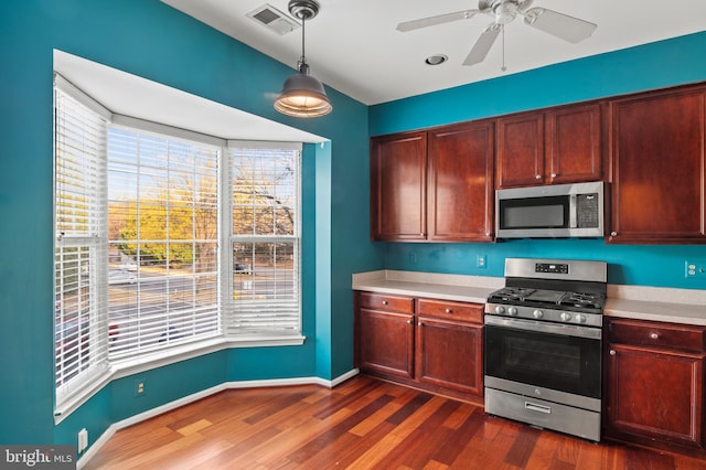 kitchen with decorative light fixtures, stainless steel appliances, dark hardwood / wood-style floors, and ceiling fan