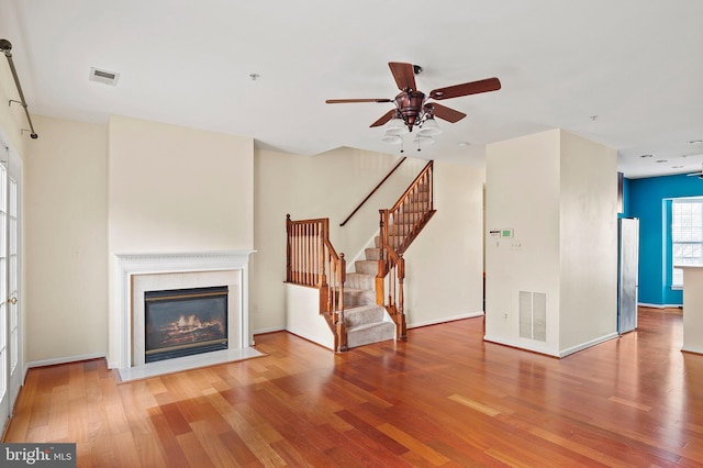 unfurnished living room featuring ceiling fan and wood-type flooring