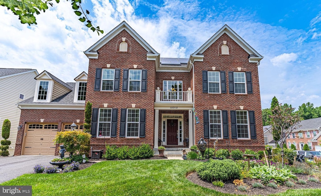 view of front of home featuring a balcony, a garage, and a front lawn