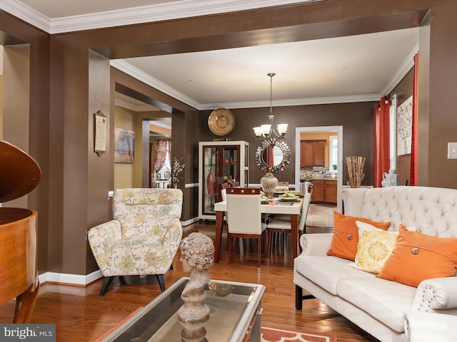 living room with hardwood / wood-style flooring, a notable chandelier, and ornamental molding