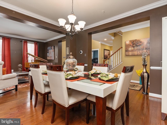 dining room featuring hardwood / wood-style floors, a chandelier, and crown molding