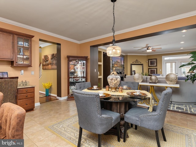 dining space with ceiling fan, light tile patterned floors, and crown molding