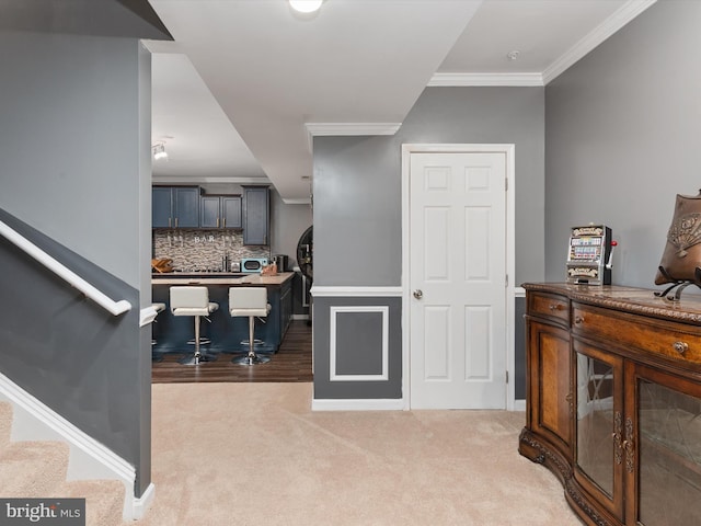 entrance foyer with light carpet and crown molding