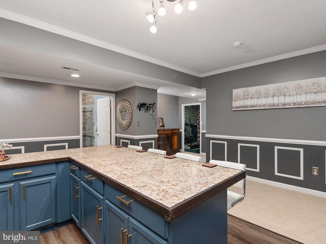 kitchen featuring ornamental molding, blue cabinetry, and dark hardwood / wood-style floors