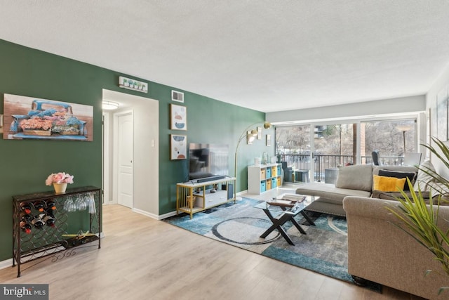 living room with a textured ceiling and light wood-type flooring