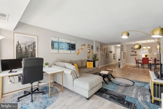 living room featuring a chandelier and light hardwood / wood-style floors