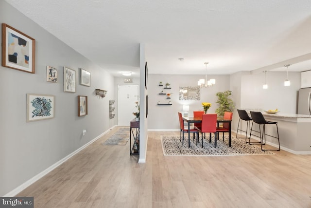 dining space featuring a notable chandelier and light hardwood / wood-style floors