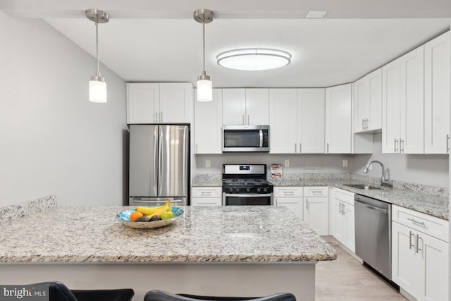 kitchen with stainless steel appliances, white cabinetry, and a breakfast bar area