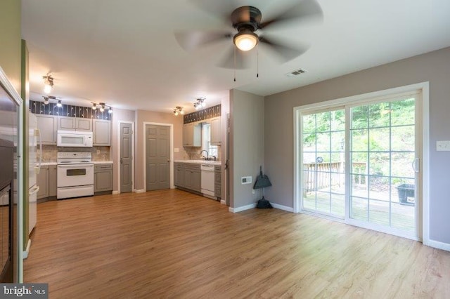 kitchen with gray cabinetry, ceiling fan, light hardwood / wood-style flooring, white appliances, and decorative backsplash