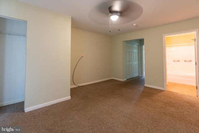 unfurnished bedroom featuring ensuite bathroom, carpet floors, and ceiling fan