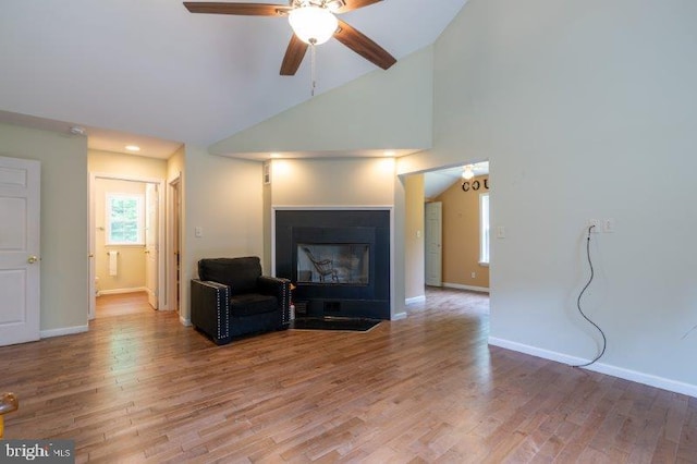 living room with ceiling fan, hardwood / wood-style floors, and high vaulted ceiling