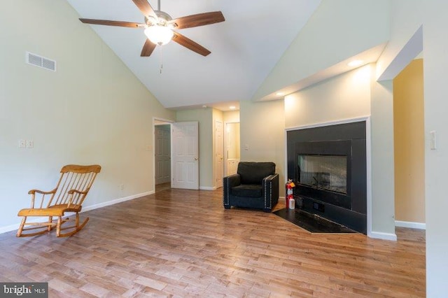 sitting room with light hardwood / wood-style floors, high vaulted ceiling, and ceiling fan