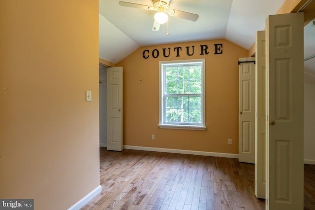 unfurnished bedroom featuring ceiling fan, vaulted ceiling, and light wood-type flooring