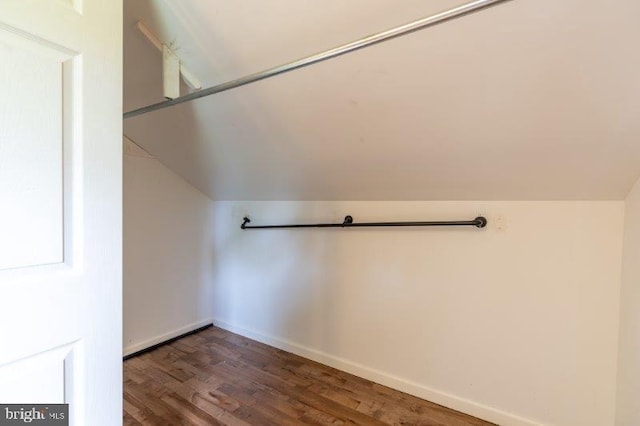 bonus room with dark wood-type flooring and vaulted ceiling