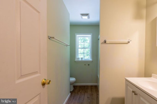 bathroom with vanity, wood-type flooring, and toilet