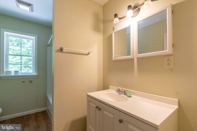 bathroom with plus walk in shower, wood-type flooring, and vanity