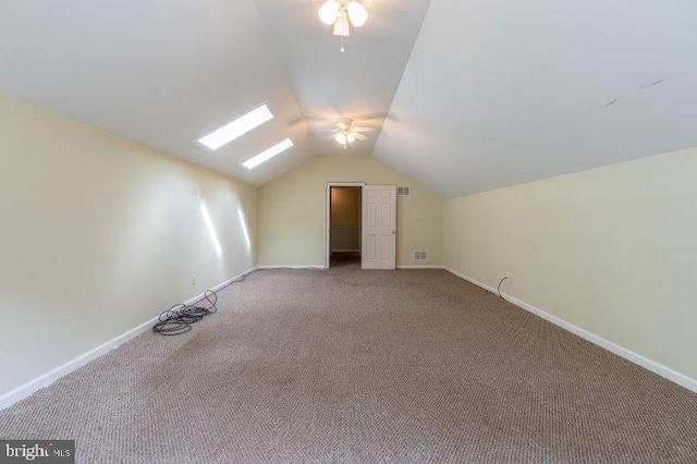 bonus room with lofted ceiling with skylight, carpet, and ceiling fan