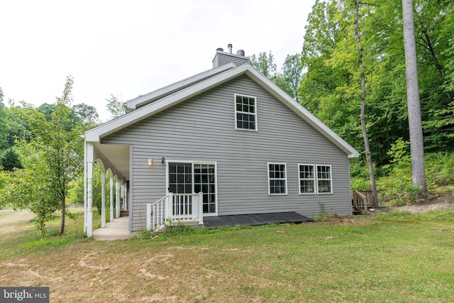 rear view of property featuring a lawn