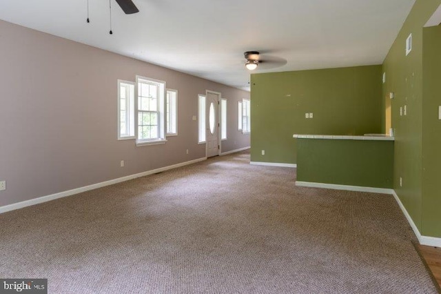 carpeted spare room with ceiling fan