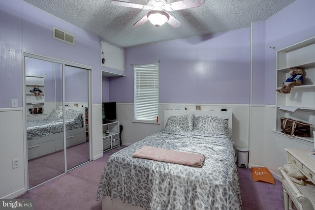 bedroom featuring light carpet, a textured ceiling, and ceiling fan