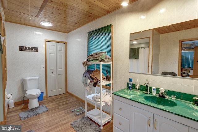 bathroom with hardwood / wood-style floors, vanity, toilet, tile walls, and wood ceiling