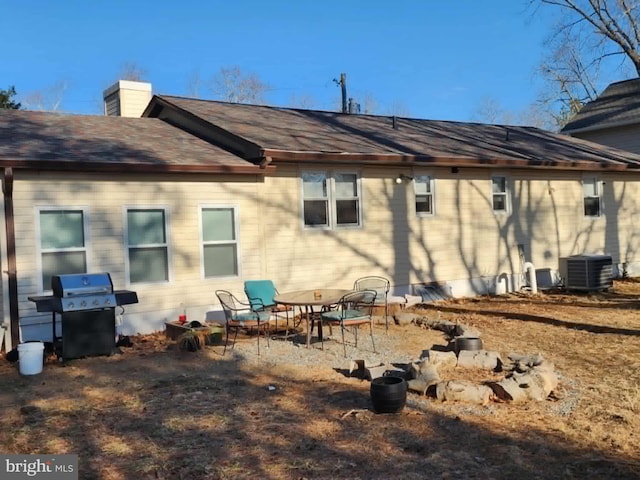 rear view of house featuring a patio, a chimney, and central air condition unit