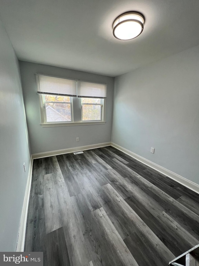 spare room with dark hardwood / wood-style flooring