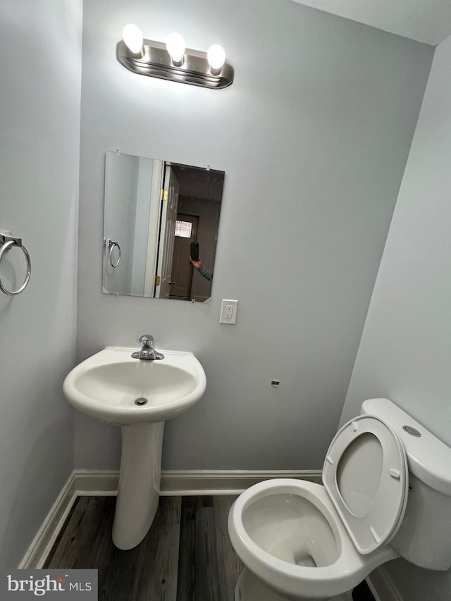 bathroom with toilet and hardwood / wood-style flooring